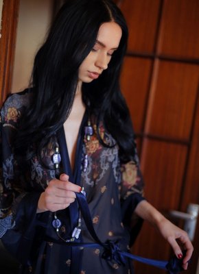 Брюнетка сняла халатик и устроилась на кровати